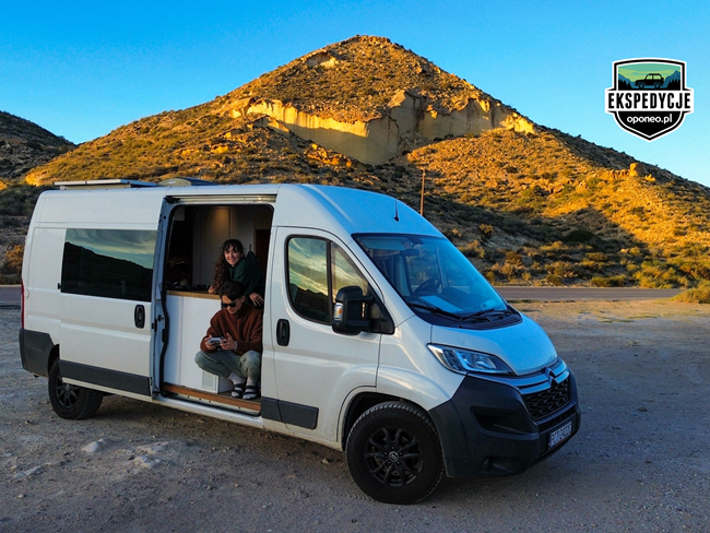 osoby w kamperze na tle góry