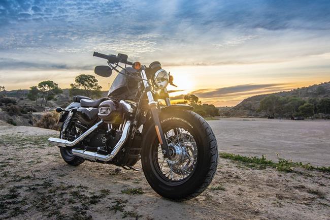 Motocykl turystyczny na plaży. W pierwszym planie przednie koło