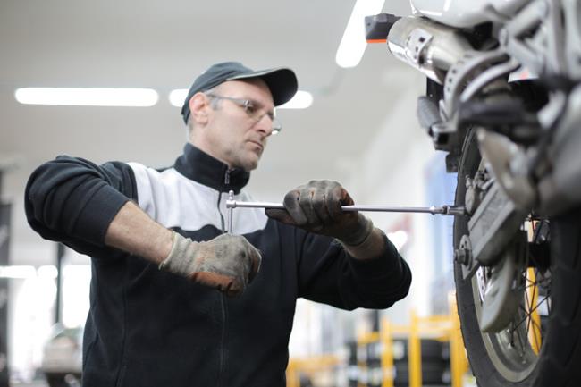 Mechanik pracujący przy kole motocykla