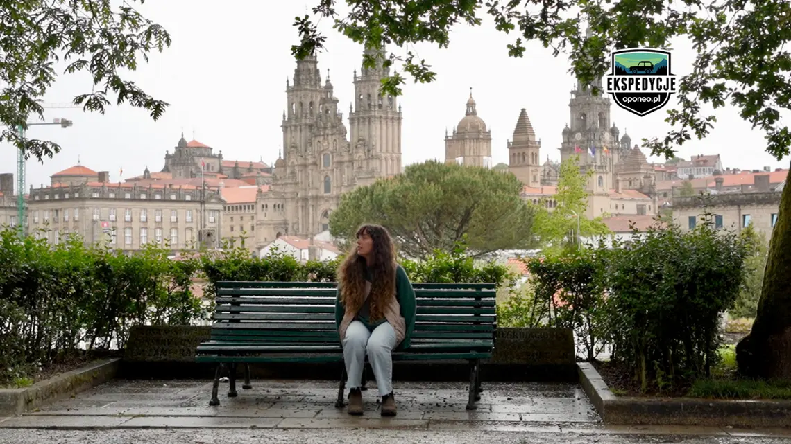 kobieta siedząca na ławce, w tle katedra Santiago de Compostela