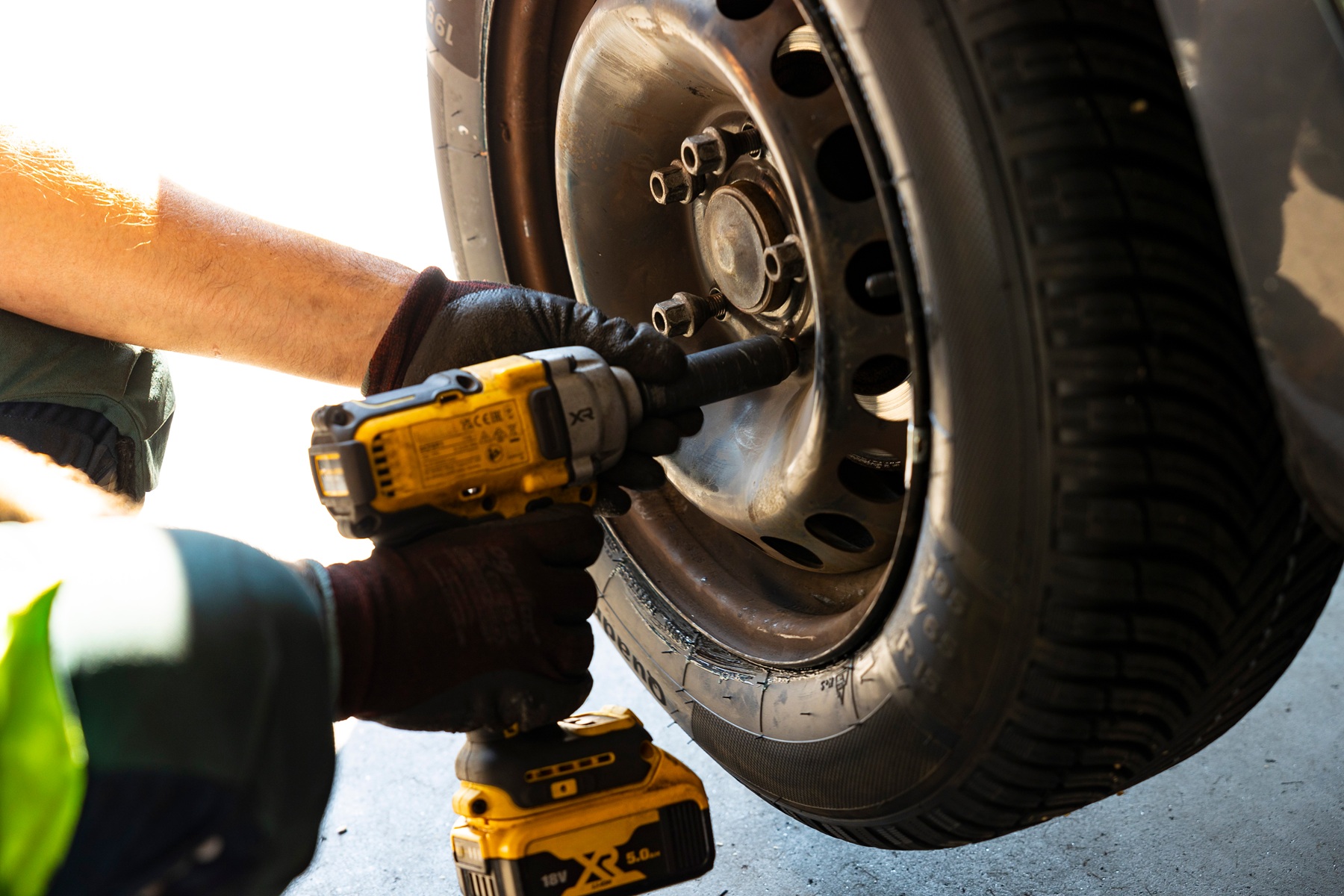 mechanik wykręcający śruby z felgi podczas wymiany opon