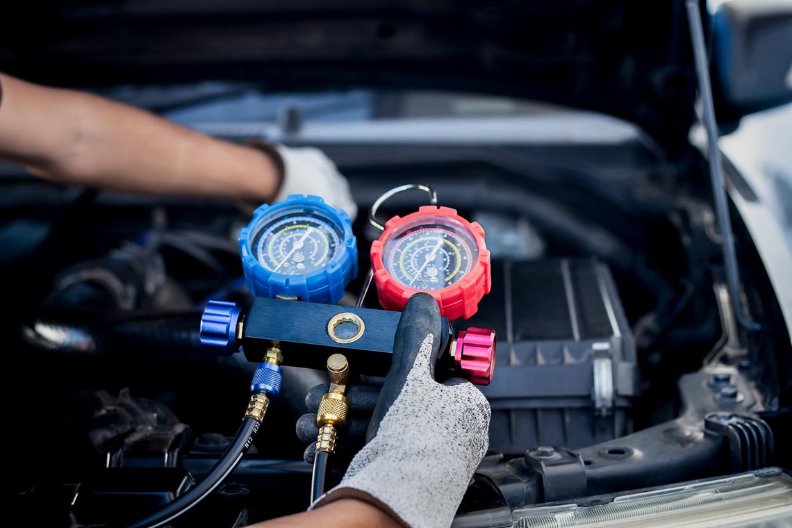 mechanik uzupełniający czynnik w układzie klimatyzacji w samochodzie