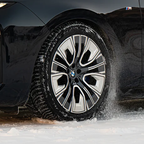 Lewy przód samochodu marki BMW podczas jazdy na ośnieżonej drodze