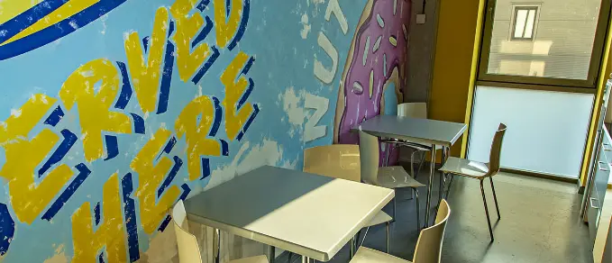 Strefa z muralem i stolikami w biurze Oponeo